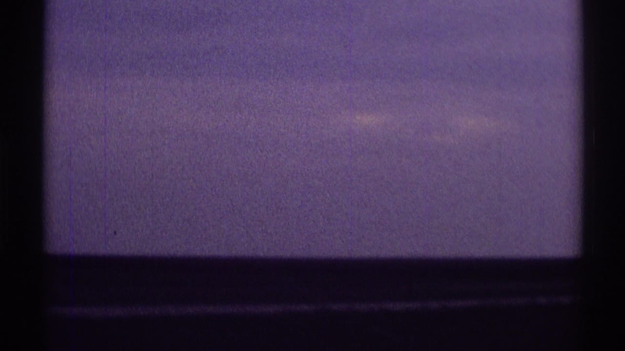Clarendon Hills 1969 travel-view frame with soft purple sky, dark window or vehicle edge, and indistinct horizon coloration.