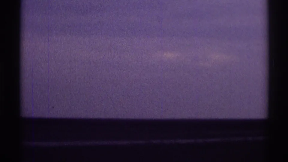 Clarendon Hills 1969 travel-view frame with soft purple sky, dark window or vehicle edge, and indistinct horizon coloration.