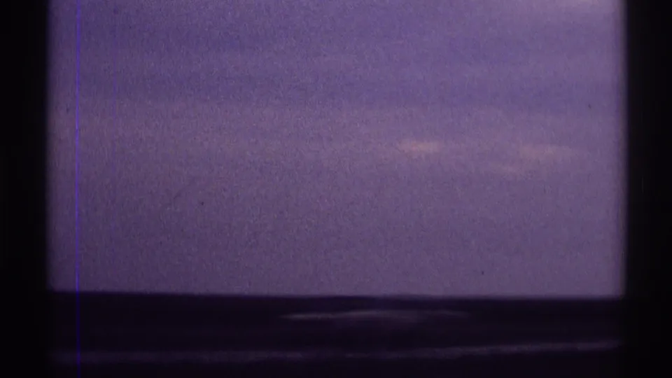 1969 8mm frame showing a passing sky view near Clarendon Hills, with dark lower framing and faint film scratches.