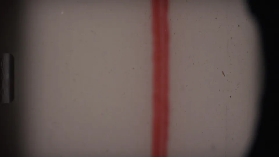 1969 Angola 8mm frame mostly obscured by gate edges, with pale film surface, dust marks, and a red vertical line.