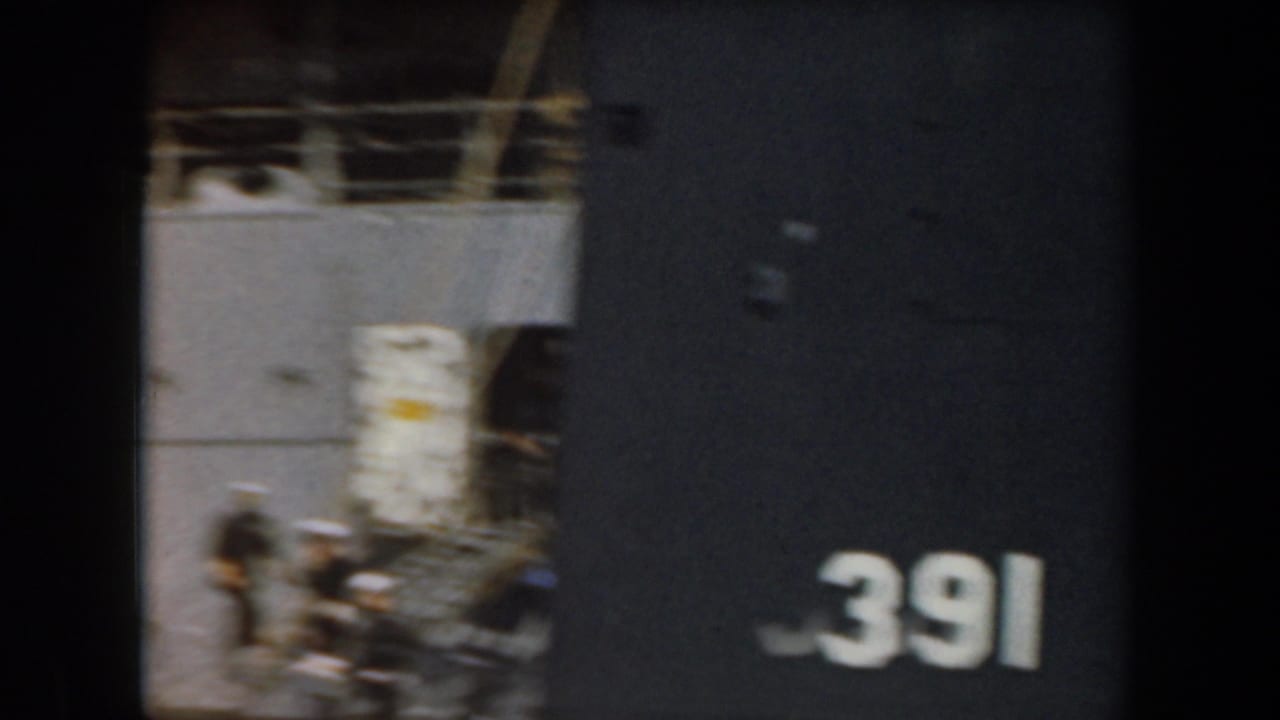 1961 California frame with a cropped grey naval vessel, deck area, and large white hull number 391 visible along the right side.