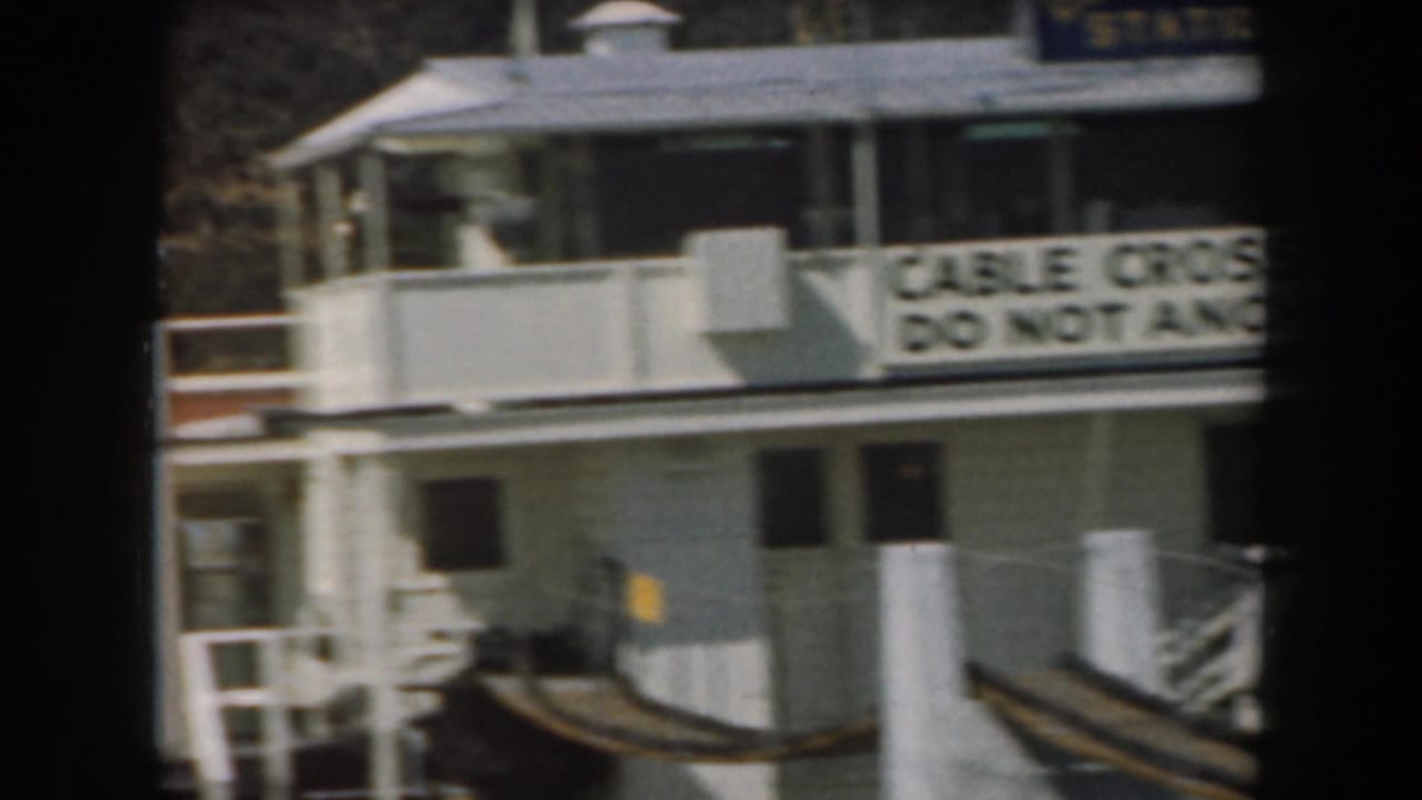California waterfront station scene with warning signage, railings, dock structures, and a small boat partly visible.