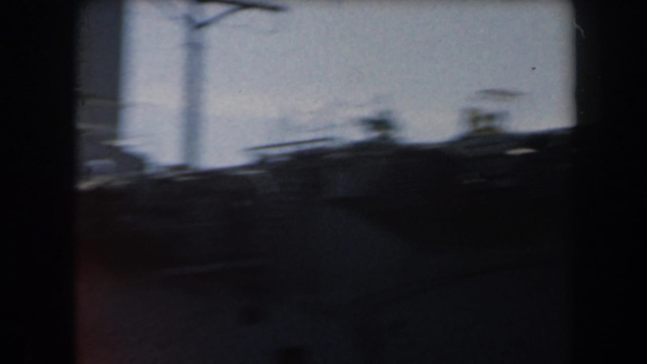 Dark, blurred ship profile with antenna shapes and a vertical mast silhouetted against the sky.