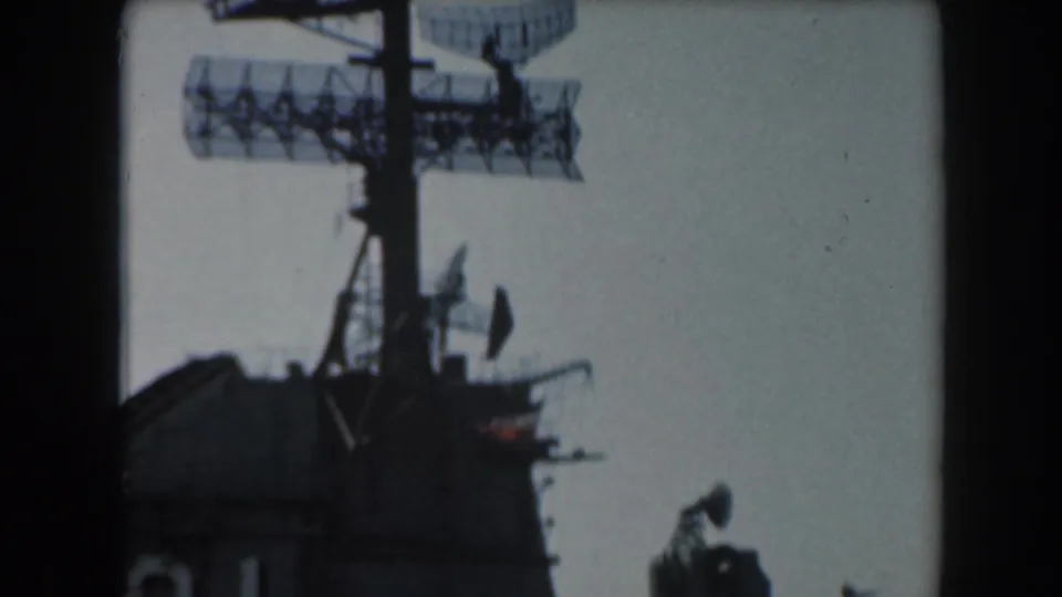 1961 California 8mm frame showing a dark warship superstructure, radar array, antennas, and soft film borders.