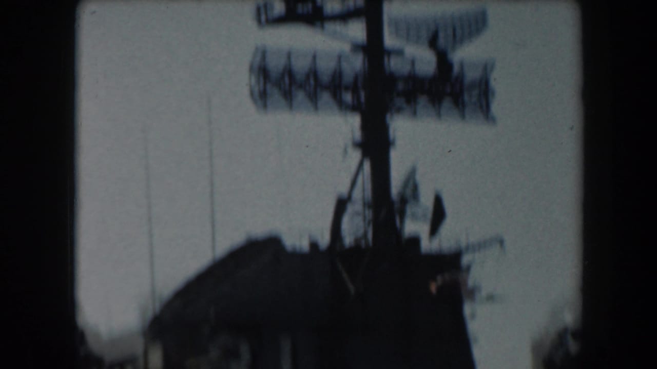 Similar view of the ship mast and radar equipment, slightly blurred.