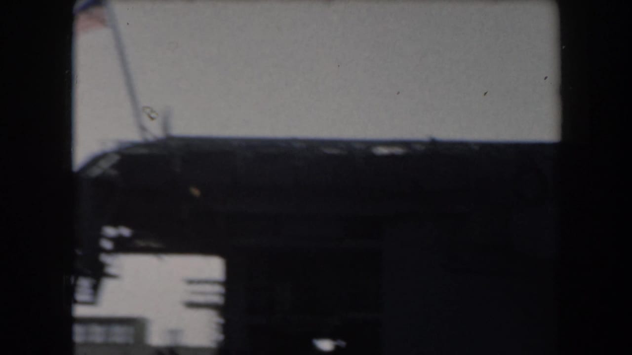 Dark section of a battleship with pale sky and partial superstructure visible.