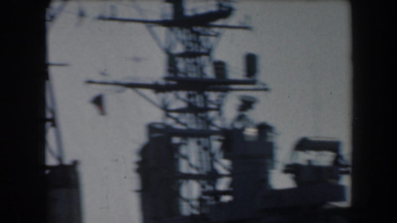 Ship mast and radar-like equipment silhouetted above the deck.