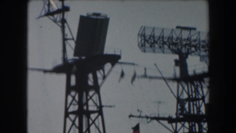 1961 California 8mm frame showing a dish-like shipboard receiver, lattice radar array, antennas, and mast supports.