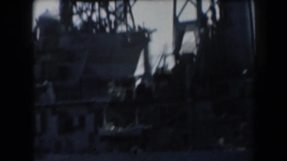 1961 California 8mm frame showing dense ship superstructure, vertical masts, rigging, and shadowed equipment.