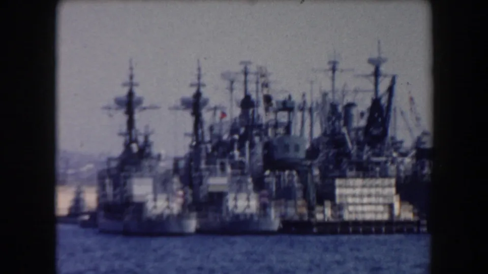 Several gray warships are docked close together in this 1961 California harbor view, their masts and superstructures filling the frame.