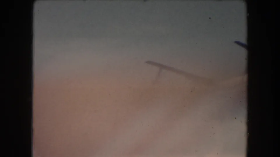 Faded 1961 8mm frame from California footage, showing pale sky tones, soft exposure, and dark film borders before the ride view appears.