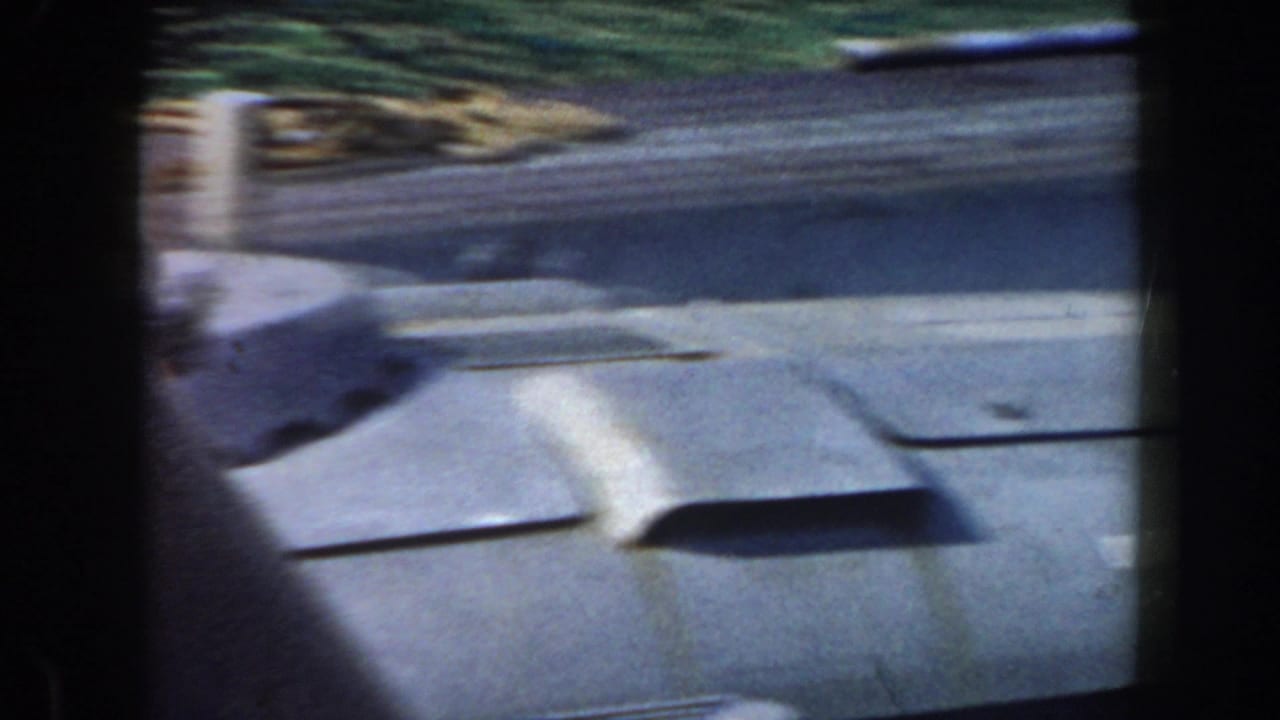 Gray ship deck with raised vents or hatches, seen from a moving angle.