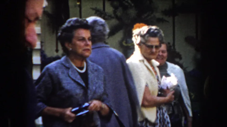 In California archival home-movie footage, older women in early 1960s clothing stand together outdoors in partial sunlight.