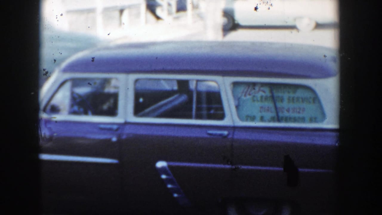 Side view of the parked station wagon with a service sign visible in the rear window.