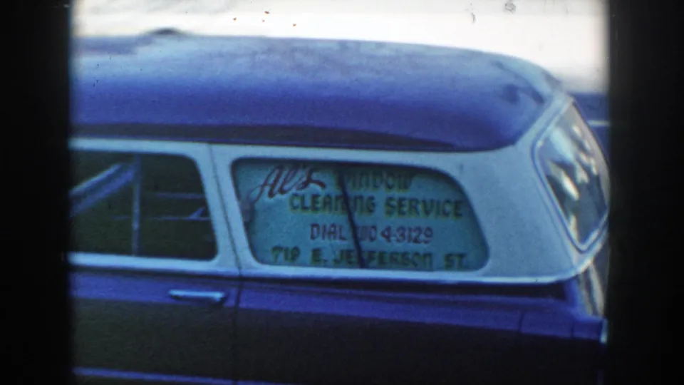 The car window sign reads as All Window Cleaning Service with a phone number and Jefferson Street address visible on the glass.