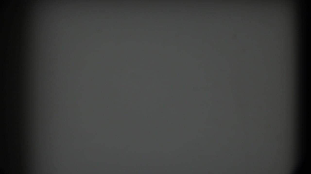 Blank gray film frame with dark vignette edges and a soft vertical shadow.