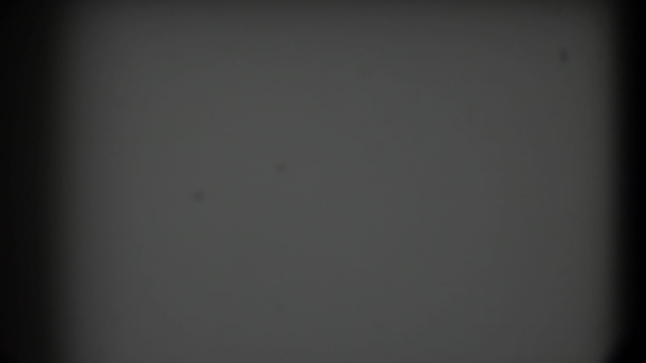 Soft, mostly gray 8mm frame with a dark vertical gate edge and visible grain from the 1958 Texas footage.