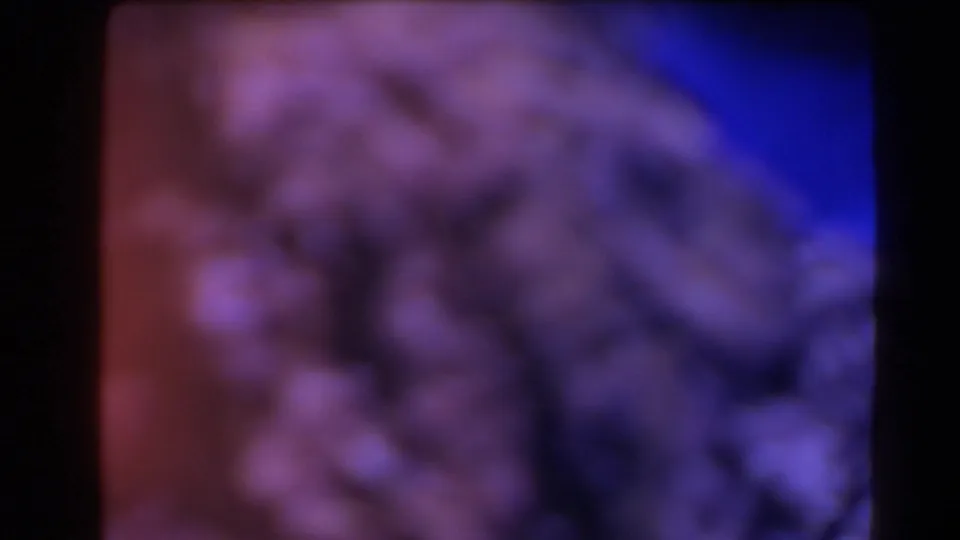 1958 Texas 8mm frame showing an abstract close view of grey rocks, blue-purple shadow, and reddish film exposure.