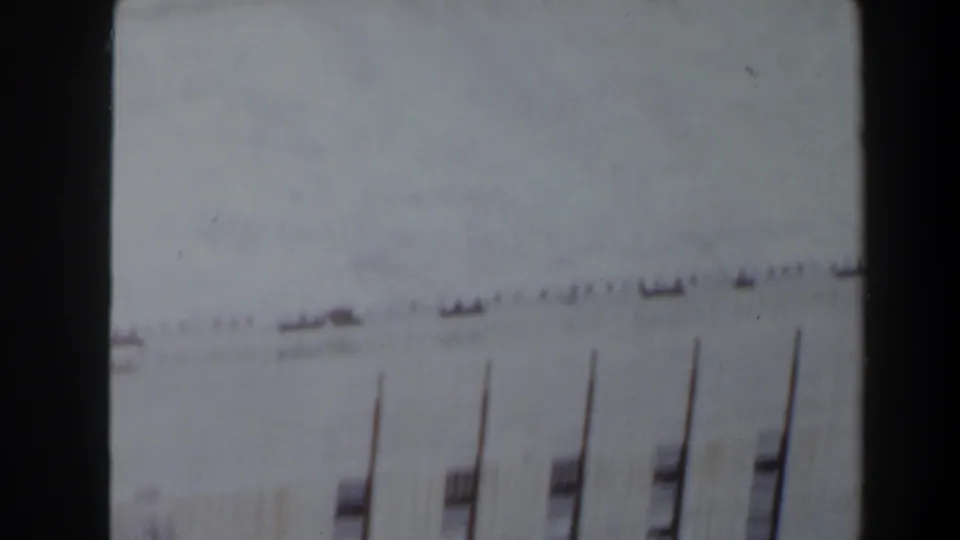 Faded 8mm frame of the Max Starcke Dam facade in Texas, with small upper openings and vertical window bays visible.