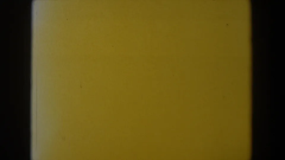 Yellow-tinted 8mm end frame with visible film borders, grain, and minimal detail.