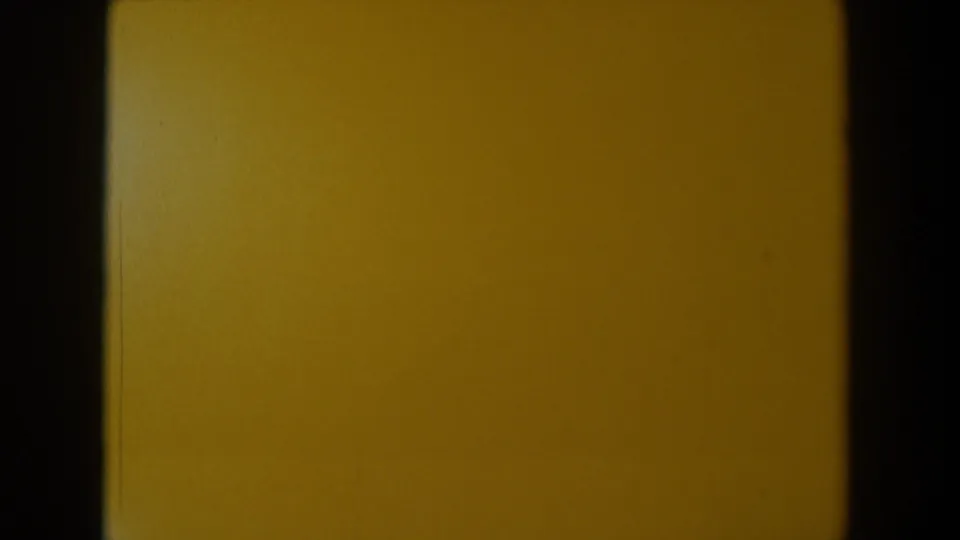 1958 Texas 8mm frame showing a mostly yellow blank field bordered by dark film edges, with dust and uneven exposure.