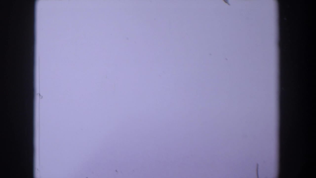 1958 Texas 8mm frame showing a pale lavender exposure field with dark film borders, dust, and minor scratches.