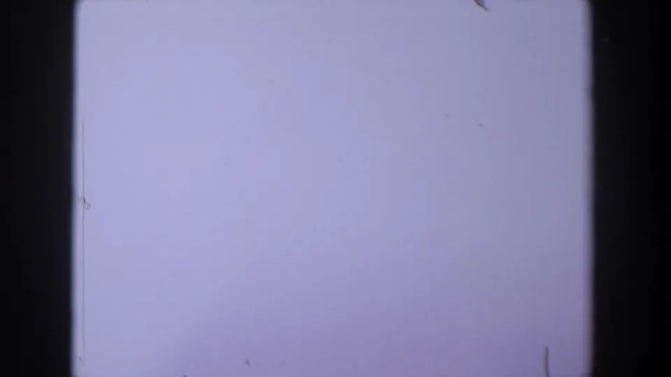 1958 Texas 8mm frame showing a pale lavender exposure field with dark film borders, dust, and minor scratches.