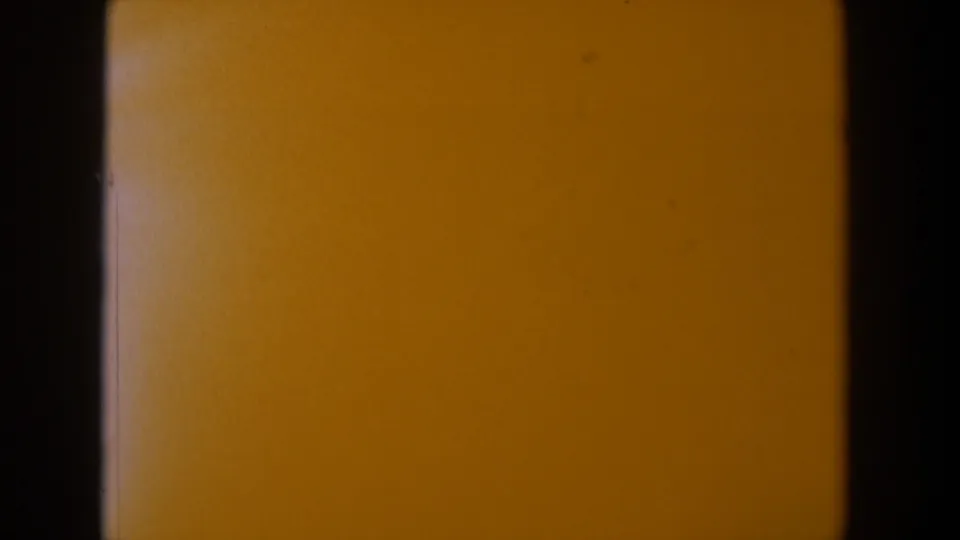 1958 Texas 8mm frame dominated by yellow-orange contamination, with black frame edges and subtle grain.