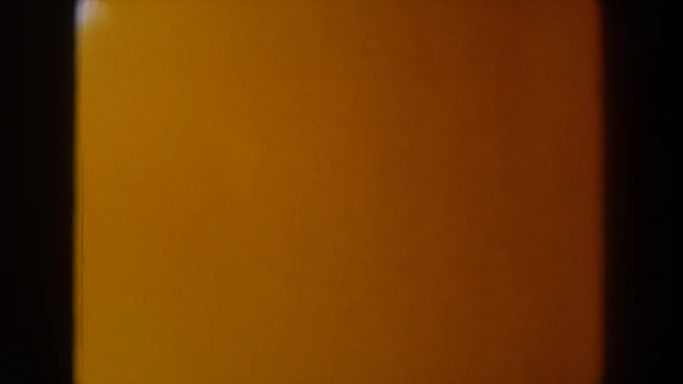 1958 Texas 8mm frame filled with deep amber color contamination, dark vertical borders, and visible film texture.