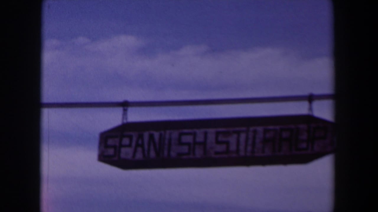 Hanging sign reading Spanish Stairs against a purple-blue sky.