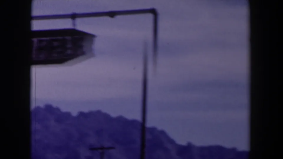 1958 Texas 8mm frame where the Spanish Stairs sign is partly cut off beside a metal pole and distant mountains.