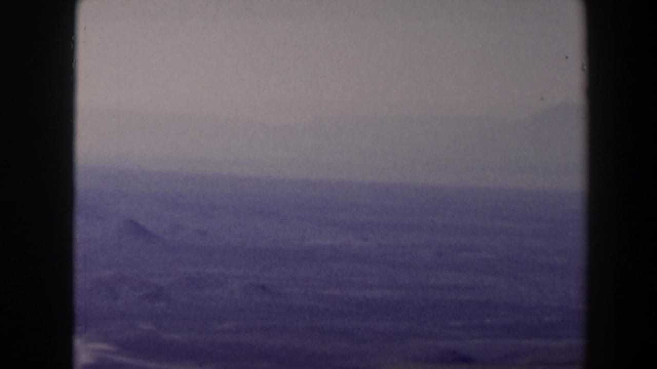Distant hazy ridges seen beyond a dry elevated slope.