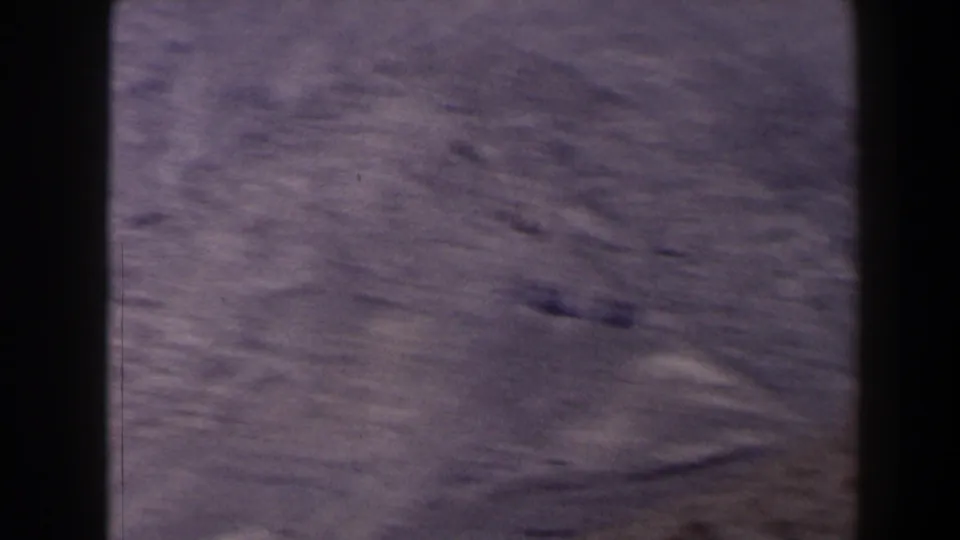 1958 Texas 8mm frame showing dry, brown ridges and sparse terrain from a high overlook, with visible film gate edges.