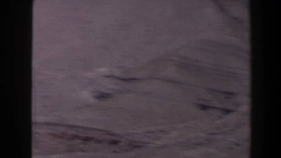 1958 Texas 8mm frame showing a sparse desert basin and low rises from a mountain overlook, with no visible people or buildings.