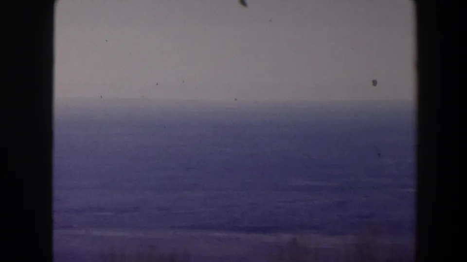 1958 Texas home-movie view of open ocean and pale horizon, split by a dark central window or structural frame.