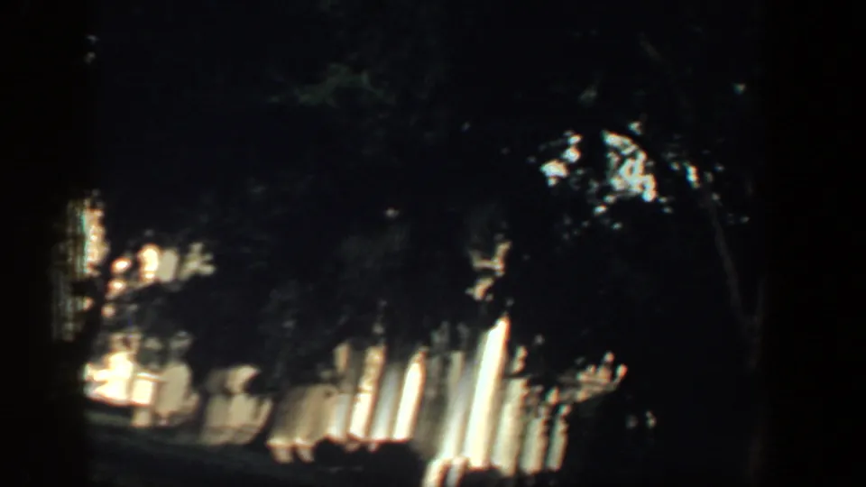 Shadowed tree cover frames a partial Washington DC landmark view in vintage 8mm footage from 1961.