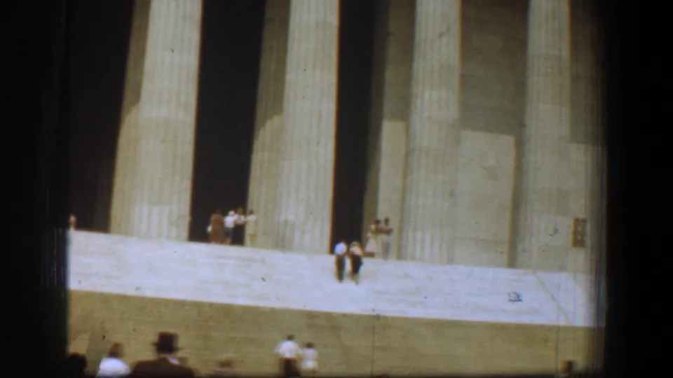 1961 Washington, DC frame showing the Lincoln Memorial entrance, broad steps, and distant visitors in mid-century home-movie color.