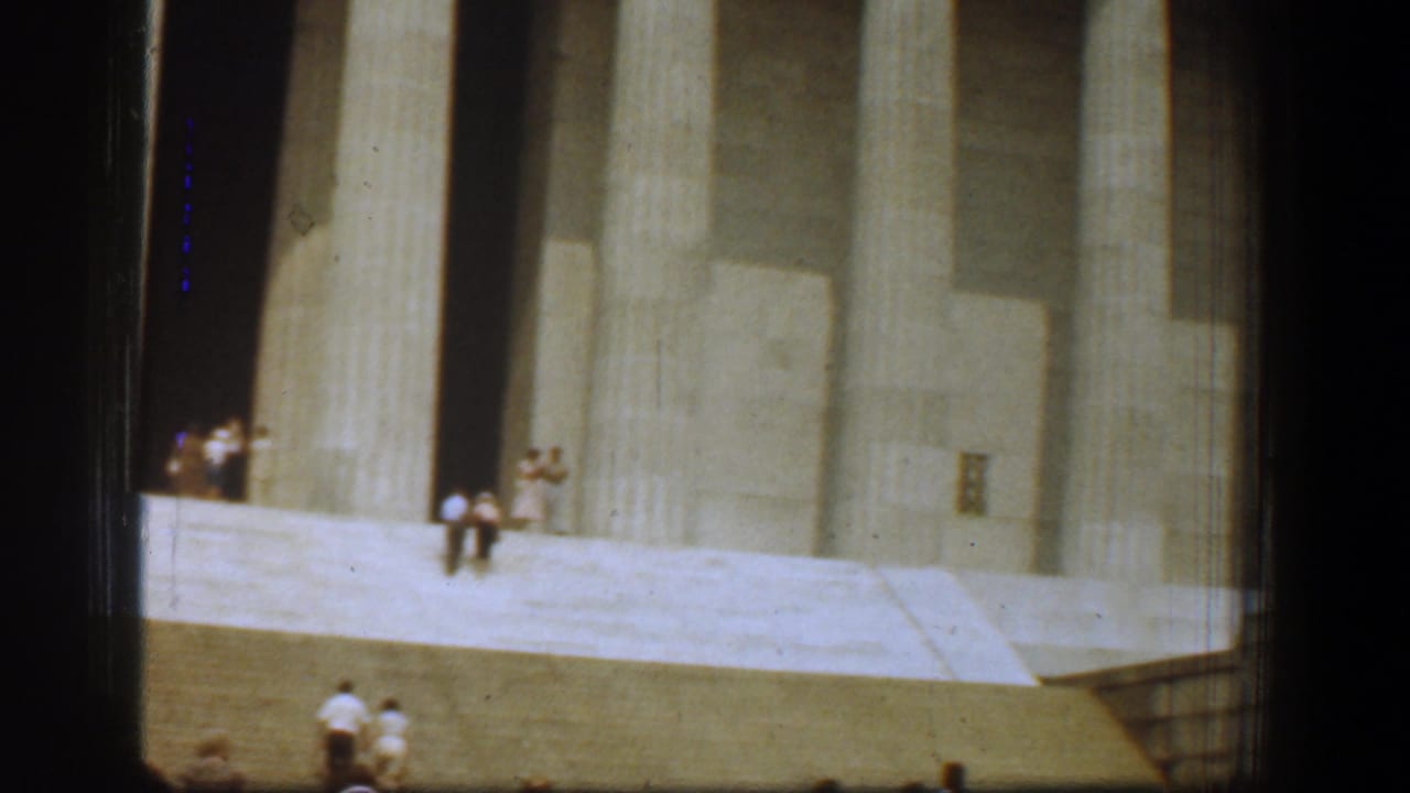 1961 8mm view of the Lincoln Memorial steps and tall columns with distant visitors in Washington, DC.