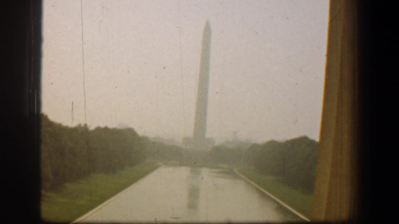 Washington Monument seen across the Reflecting Pool through a vehicle window.