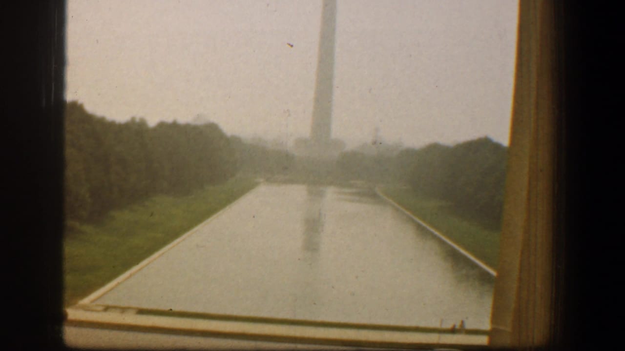 Reflecting Pool leading toward the Washington Monument with trees on both sides.