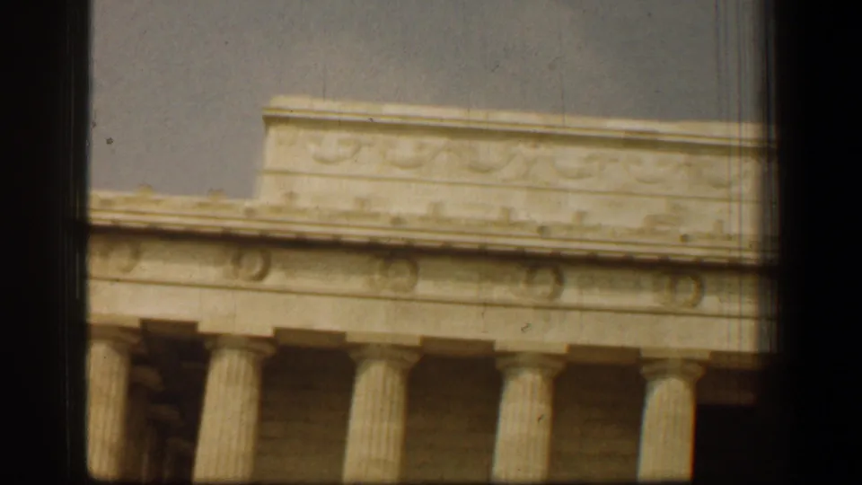 Tight visitor-shot 8mm frame of the Lincoln Memorial colonnade and decorative frieze in Washington, DC.