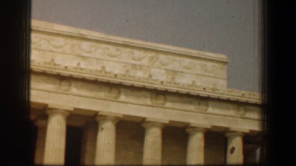 Angled 1961 Washington DC home-movie view of the Lincoln Memorial, emphasizing its roofline, frieze, and fluted columns.