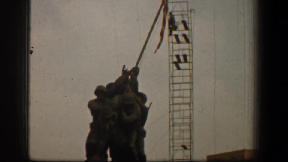 Washington, D.C. 1961 home-movie frame showing the Marine Corps War Memorial, adjacent scaffolding, and a small structure edge at lower right.