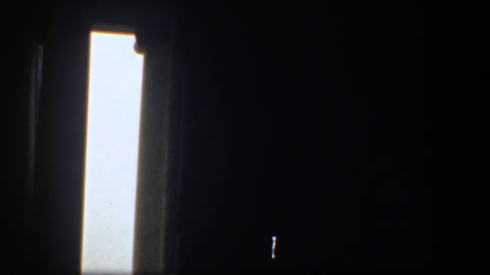 1961 Washington DC home-movie frame looking from a dark museum interior toward a bright outdoor opening.