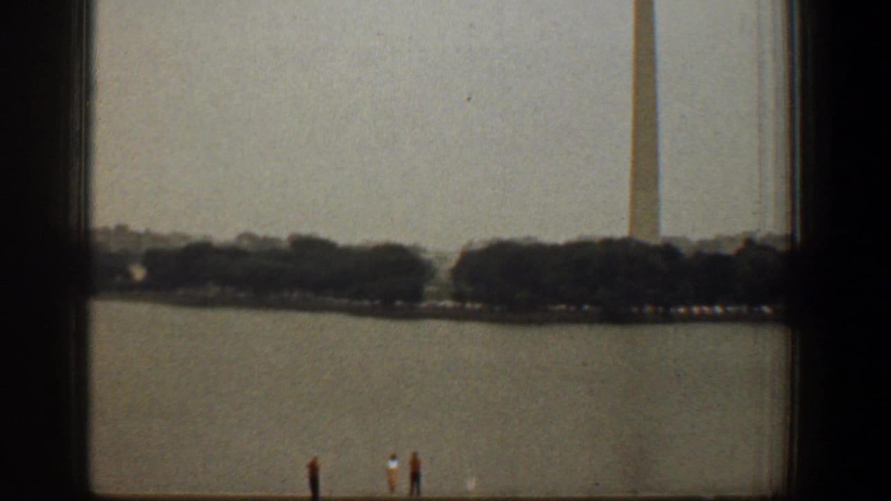 1961 Washington DC home-movie view of the Washington Monument across the Reflecting Pool, partly obscured by a dark window frame.