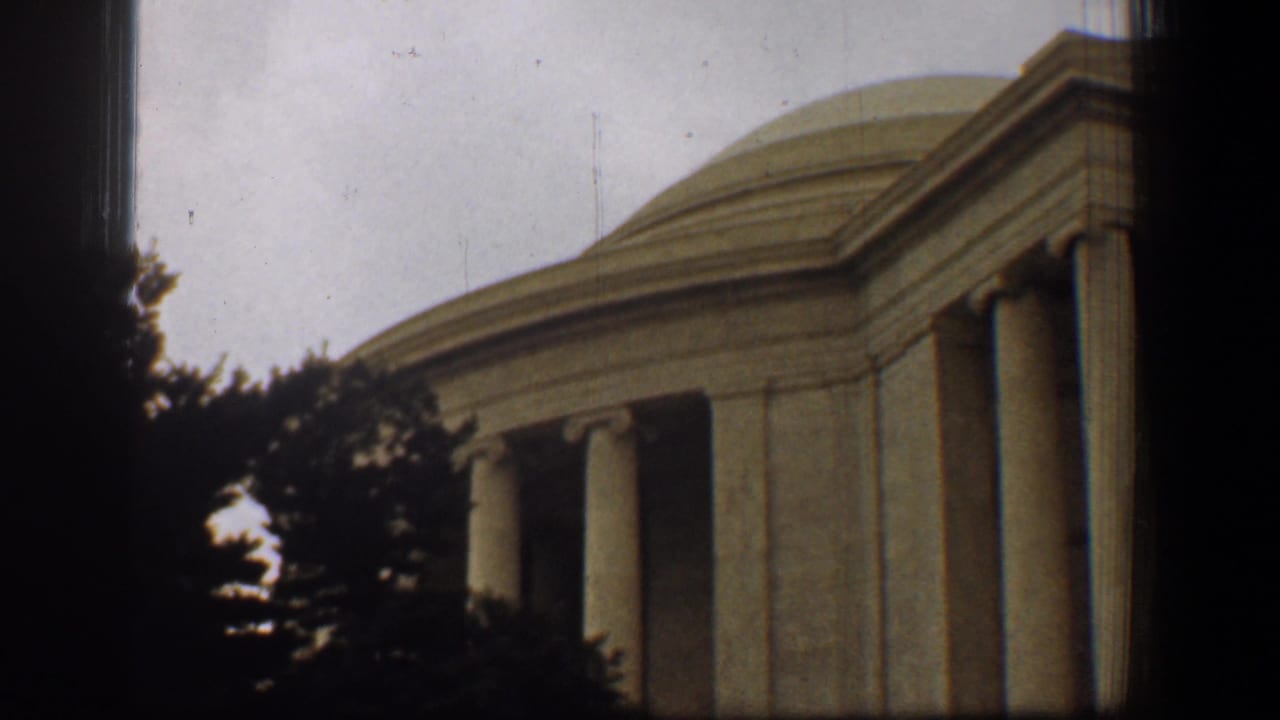 1961 Washington, DC home-movie frame showing the Jefferson Memorial dome, columns, trees, and heavy dark borders.