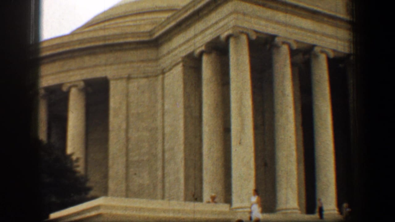 1961 Washington, DC view of the Jefferson Memorial columns and stone facade, with dark borders and small visitors near the base.