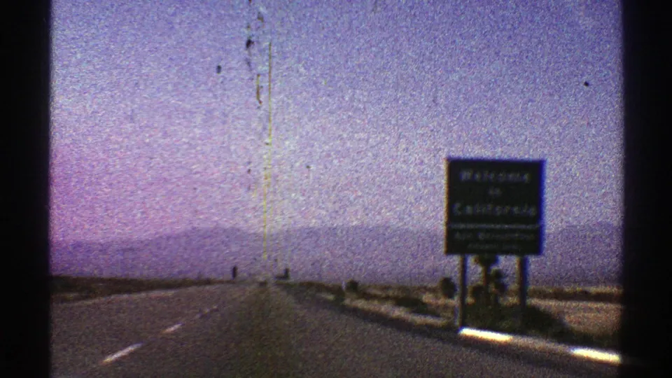 1969 8mm road footage near the Nevada-California border, with a Welcome to California sign beside the highway.