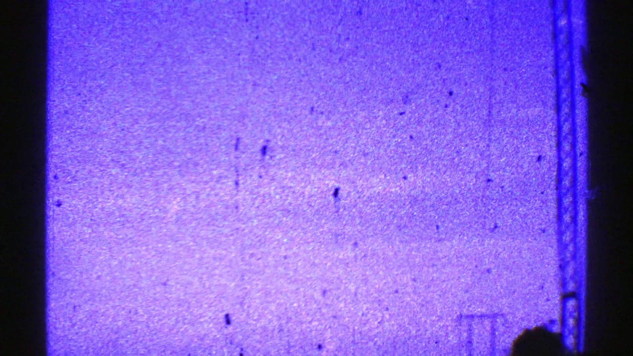Blue sky with faint electrical structures and a dark vertical post near center.