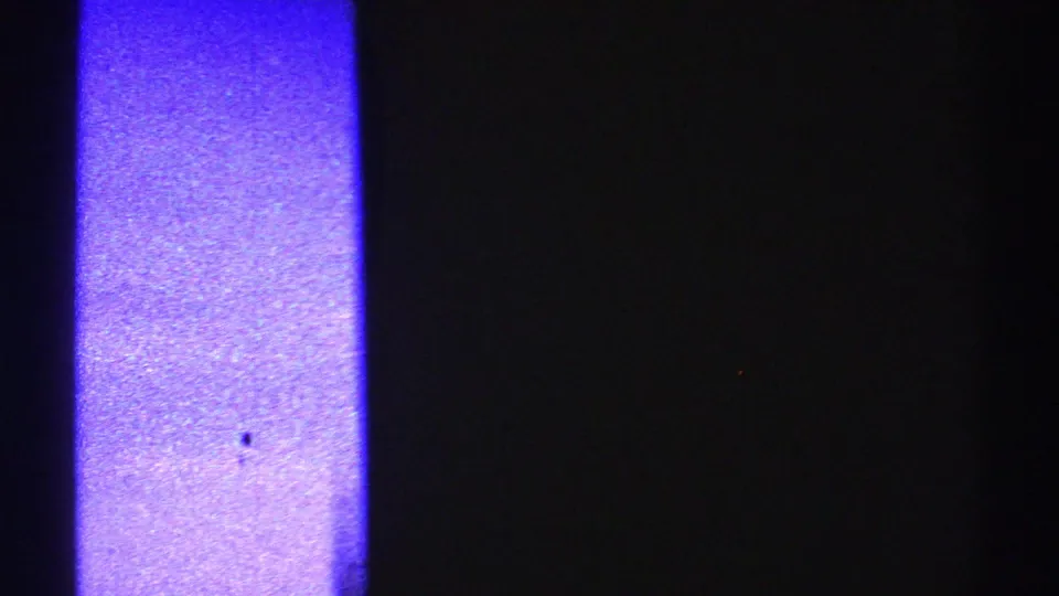 1969 Nevada 8mm frame with dark pole-like silhouettes, blue-purple exposure, and visible surface wear.
